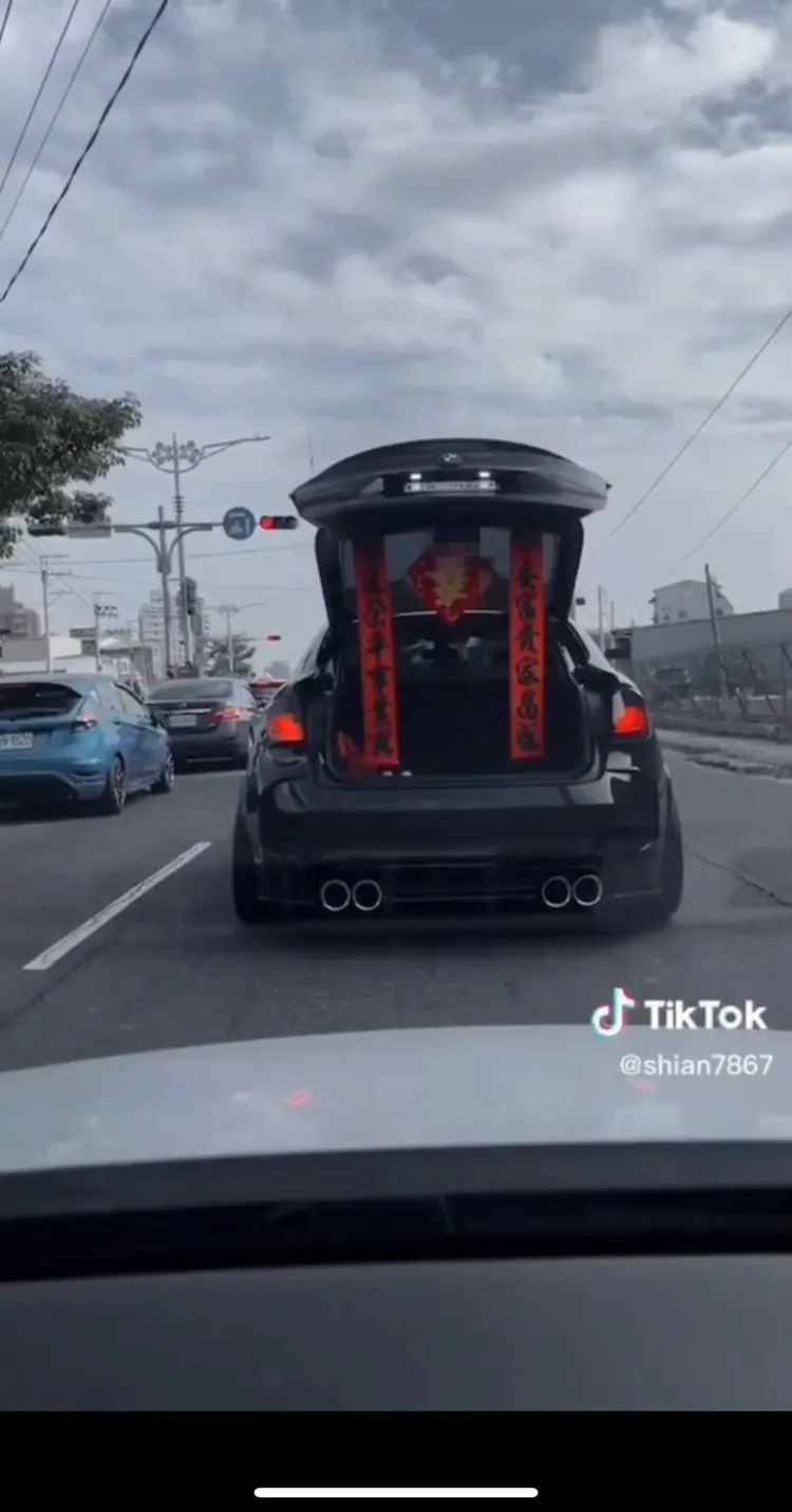 BMW停下開啟後車廂，映入眼簾的是應景的拜年春聯。翻攝YouTube《記者新聞網》