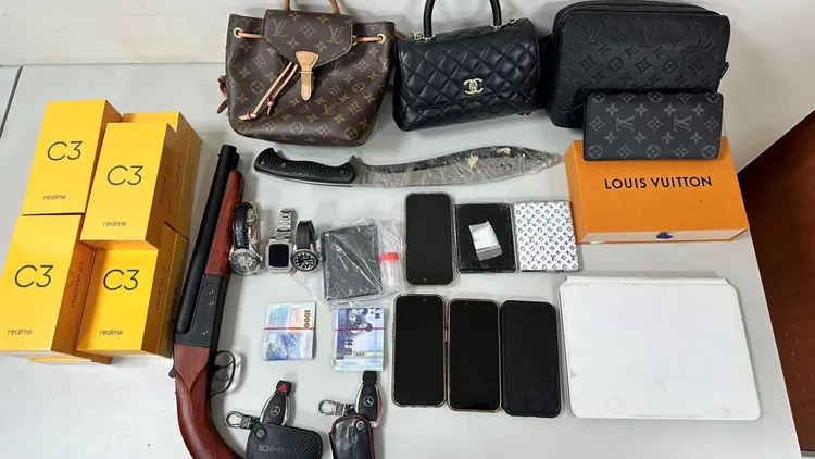 警方查扣的200多萬元不法所得、香奈兒、LV等名牌包、開山刀等贓證物。讀者提供