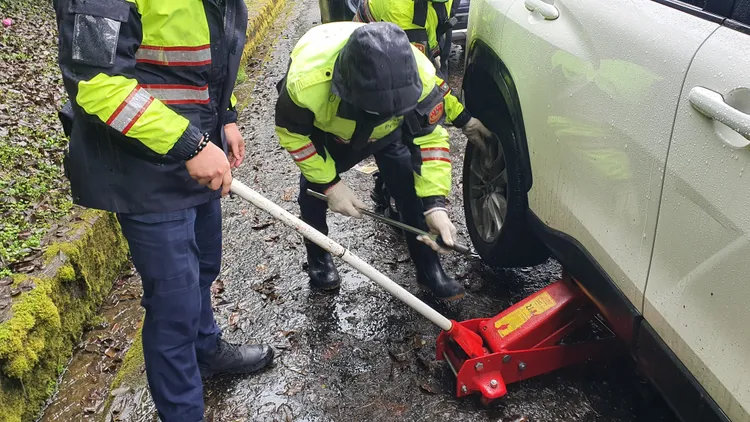 休旅車在中橫公路爆胎，警方拿出警車備胎更換協助脫困。警方提供