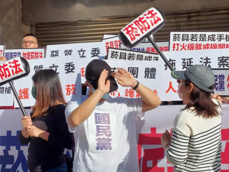 媽媽志工拿著貼有「菸防法」字樣的鎚子，敲醒國民黨籍立委。翻攝畫面