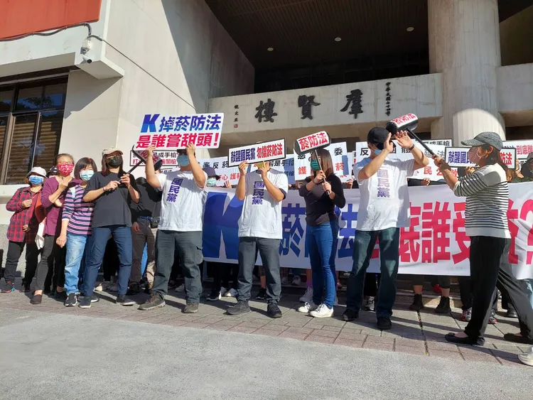 媽媽志工們聚集在立法院群賢樓前，舉字版陳情。翻攝畫面