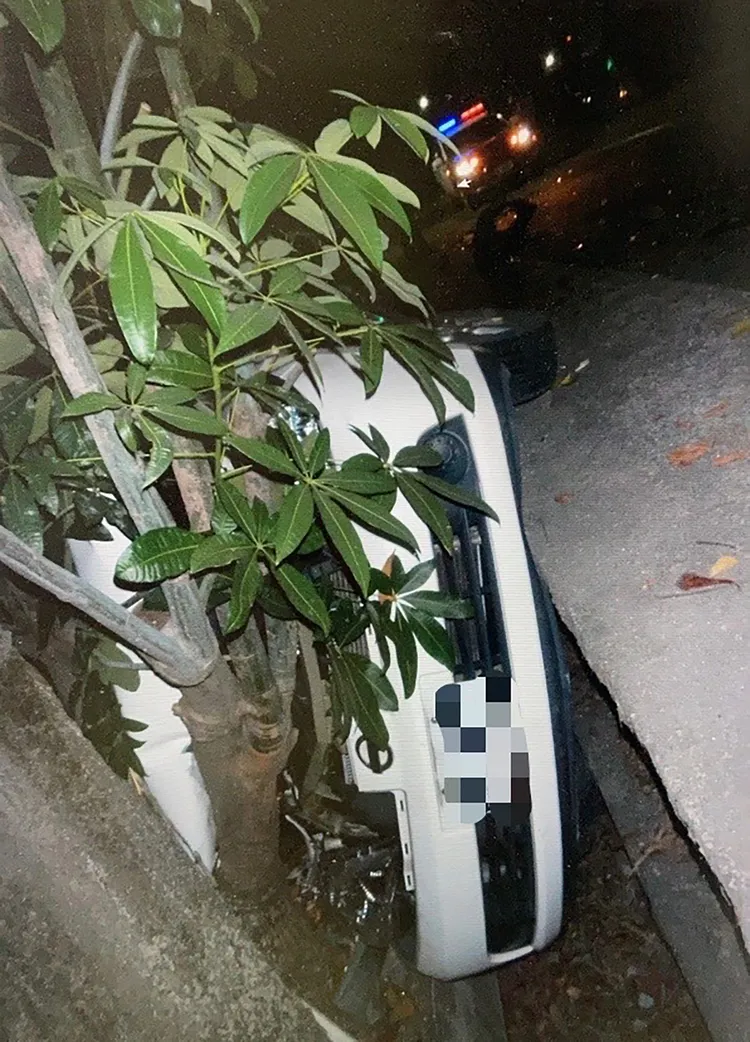 何男轎車被撞進水溝內，90度豎立卡得動彈不得。讀者提供