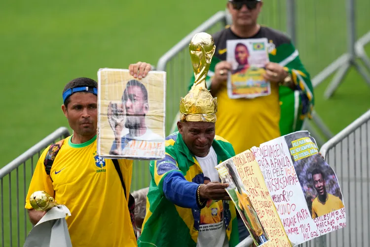 許多球迷帶著比利的照片進場。美聯社