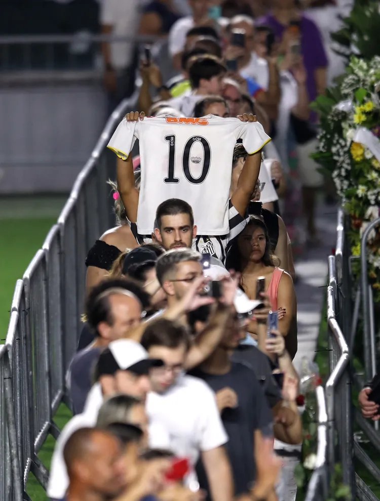 也有球迷抱著小孩子到球場排隊。路透社