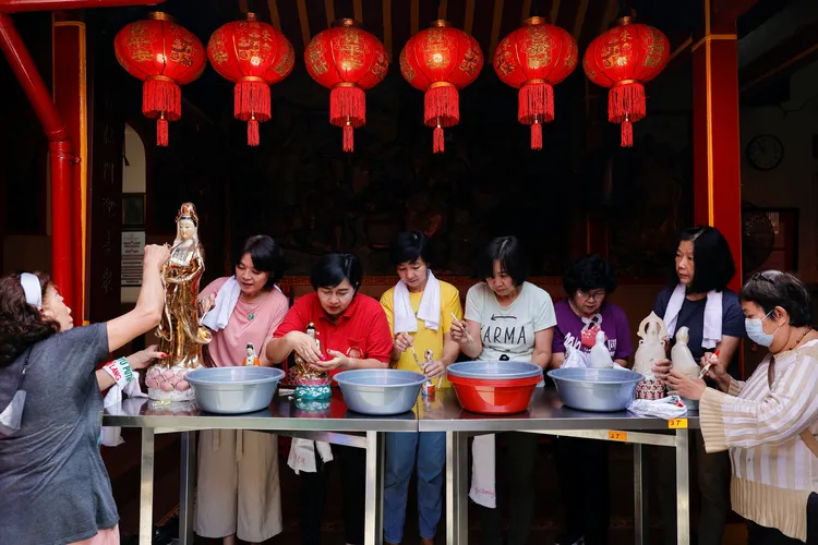 印尼福德廟的義工幫忙清潔神像。路透社