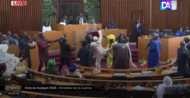 恩迪亞耶氣到要扔椅子，卻遭另一名男議員偷襲踹肚子。法新社影片截圖