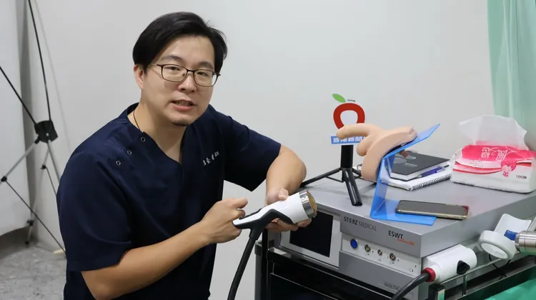 蘇信豪醫師手持打震波儀器，說明打震波有助修補與軟化白膜受傷組織，改善陰莖彎曲所致勃起或性愛疼痛。侯昌騰攝