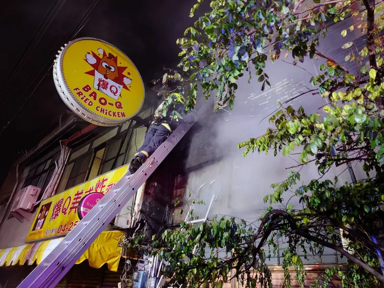 消防人員架設鋁梯登上二樓屋內進行搜救。台中市消防局提供