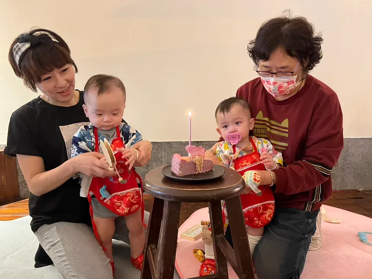 Patty（左）和阿姨抱雙胞胎吹蛋糕。趙大智攝