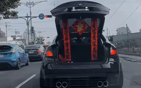 BMW停下開啟後車廂，這時看見相當應景的拜年春聯。翻攝臉書社團爆料公社