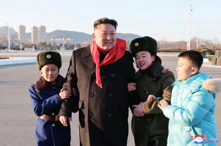 金正恩讓兒童挽著他的手。路透社