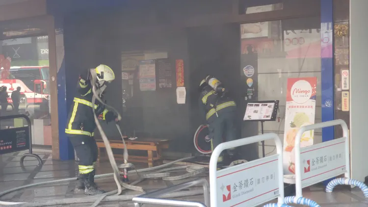燒肉店冒出濃煙，消防人員冒險滅火。王勇超攝