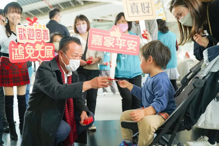 翁章梁迎接旅客返鄉，發送開運小紅包。縣府提供