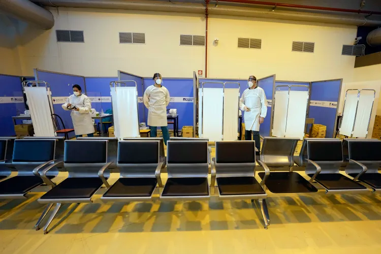 義大利羅馬機場檢疫人員等候自中國入境旅客實施抗原採檢。美聯社