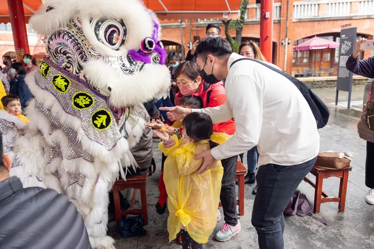 祥獅近距離與民眾互動，讓民眾「摸獅頭好采頭」。全聯善美的文化藝術基金會提供