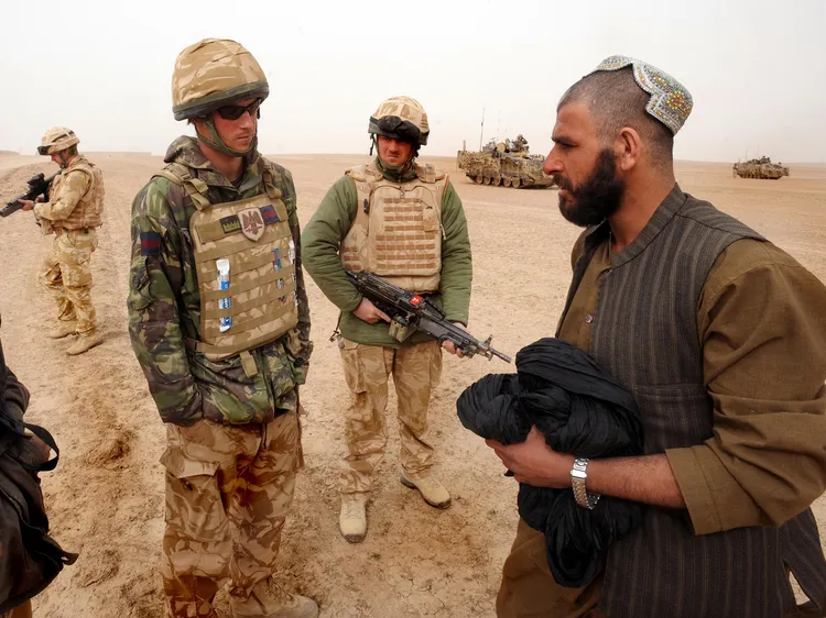 圖為2008年，英國哈利王子（圖左）在阿富汗與當地民眾講話。法新社