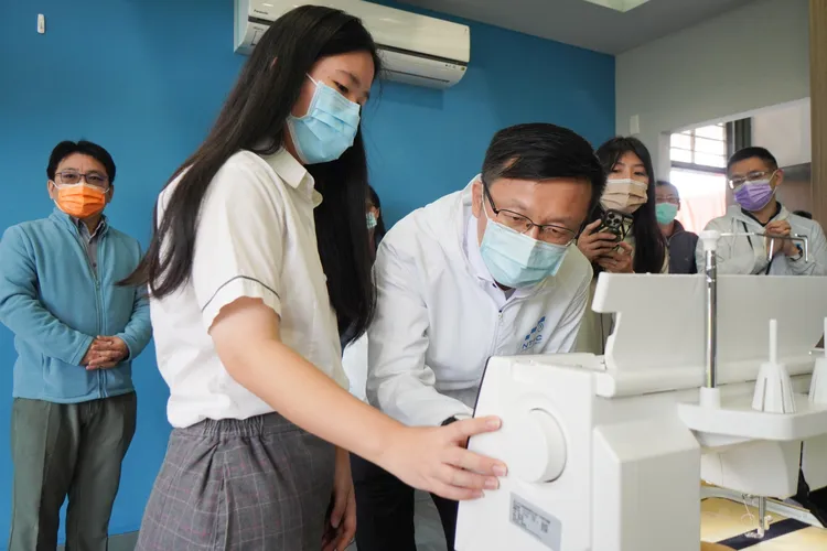 新北市教育局長張明文體驗電繡機製作紀念吊飾。翻攝畫面