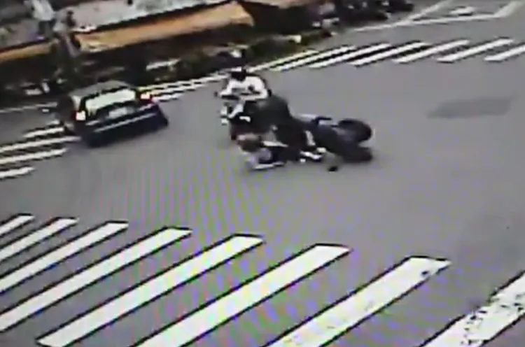 監視器拍下撞擊瞬間，騎士摔車倒地，機車180度翻轉。讀者提供