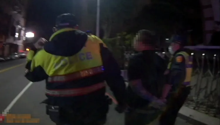 員警逮捕吳姓通緝犯帶回偵辦。警方提供