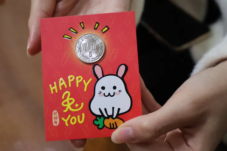 何芝寧特別準備限量500份的兔年發財金，與民眾拜年、恭賀新喜。黃羿馨攝