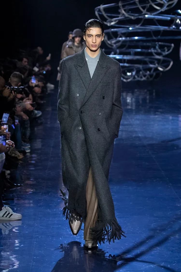 瀟灑的長版大衣在衣襬做出流蘇設計，搖曳出流動氣息。品牌提供