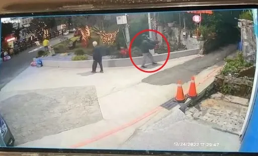 喬男(紅圈處)徒步搬運黑色塑膠袋，裡頭是重達10公斤的電線。淡水警分局提供