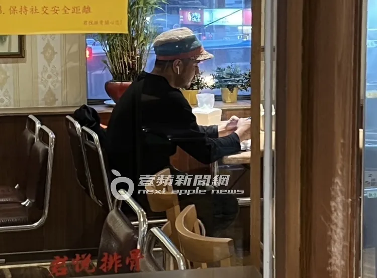 郭彥甫獨自在座位上滑手機等餐。特勤中心攝