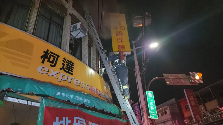 受困三樓的小孩，由消防隊員協助爬梯下樓。黃仲瑜攝