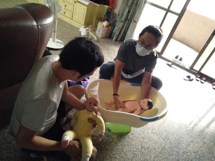 泰五林區李東穎督導示範如何幫嬰兒洗澡，為了讓爸爸看清楚，還特別將澡盆墊高。新北市府提供
