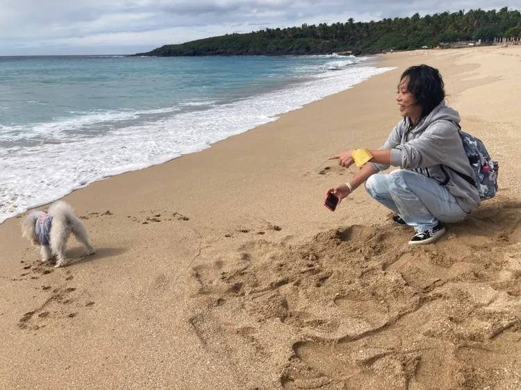台北南下的小姐與愛犬在白砂海灘嬉戲。陳宏銘攝