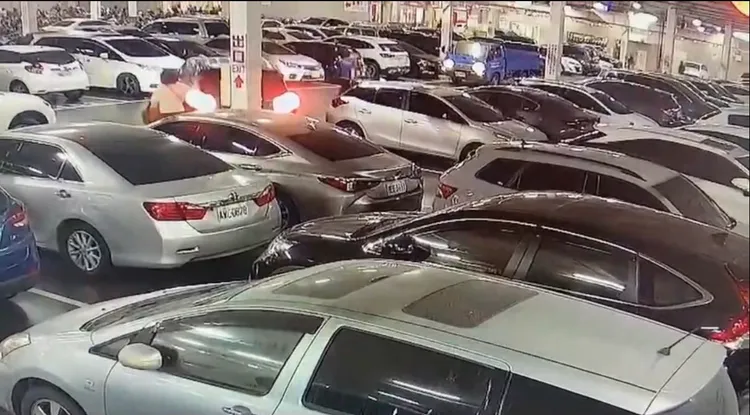 陳女的朋友（白上衣）狂拍打正在倒車的黑車，以肉身阻擋他停車。讀者提供