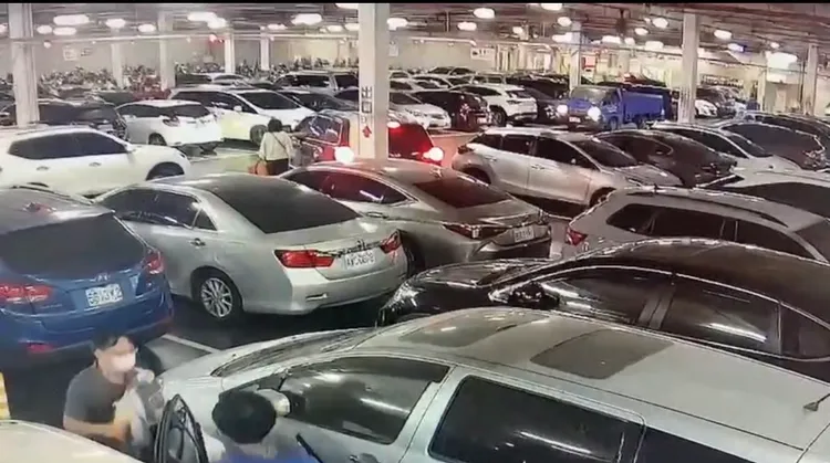 張男駕駛的黑車倒車停入好市多賣場停車格，引發後方白車陳女友（白上衣）不滿，上前理論。讀者提供