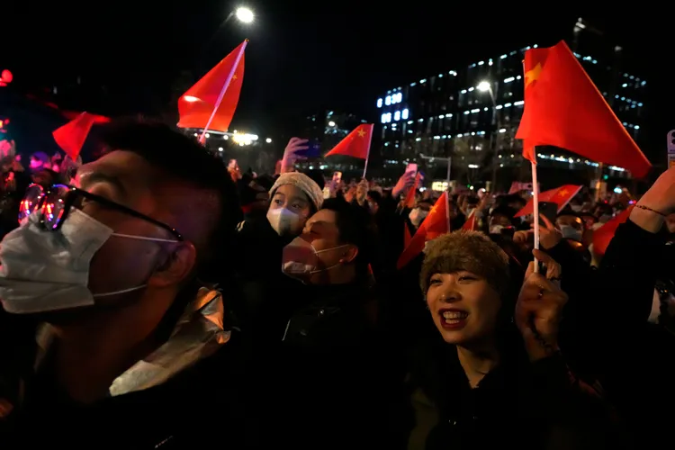 北京民眾揮舞五星旗迎接新年。美聯社