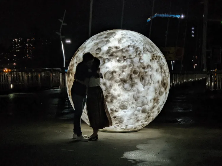 夜晚情侶在巨型月亮前合照。新北市府提供