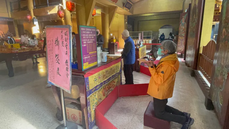 信眾擲筊求發財金。張沛森攝