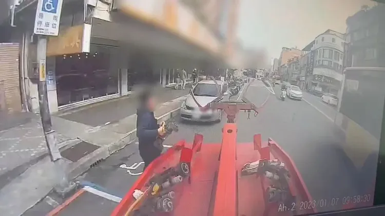 拖吊車工作人員拿著輔助輪準備裝設。中和警分局提供