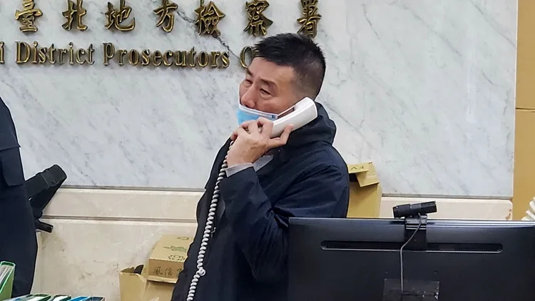 周男打電話給親友籌錢辦保。呂志明攝