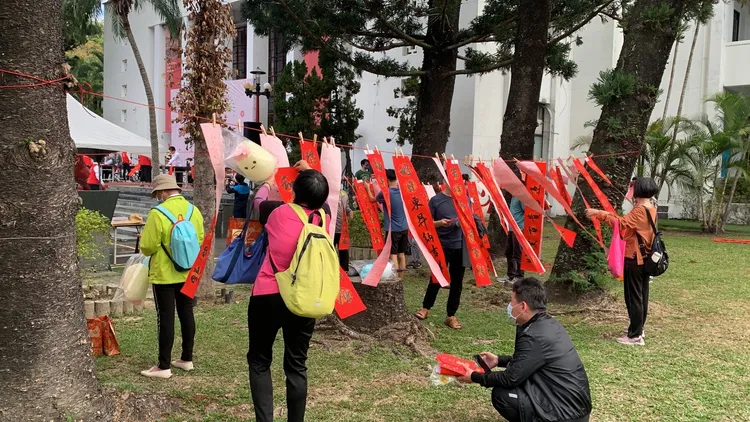 書法名家現場揮毫，取得墨寶的民眾將春聯曬在陽光下，紅色春聯隨風搖曳年味濃。曾雪蒨攝