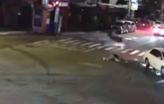 伍姓騎士撞擊後慘摔倒地，機車翻滾噴飛路旁。讀者提供