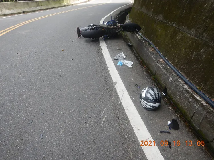 魏男被撞後失控摔到路邊水溝，送醫不治，留下機車、碎片及安全帽。民眾提供
