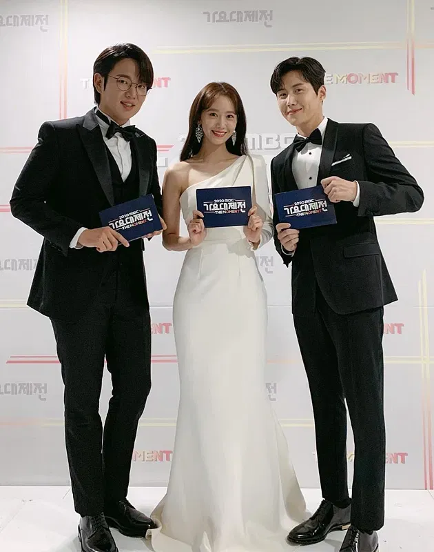 潤娥（中）在擔任「2020年MBC歌謠大賽」主持人時穿上SAFIYAAS斜肩蝴蝶結禮服登場，簡潔又浪漫。翻攝YOONA_LIM IG