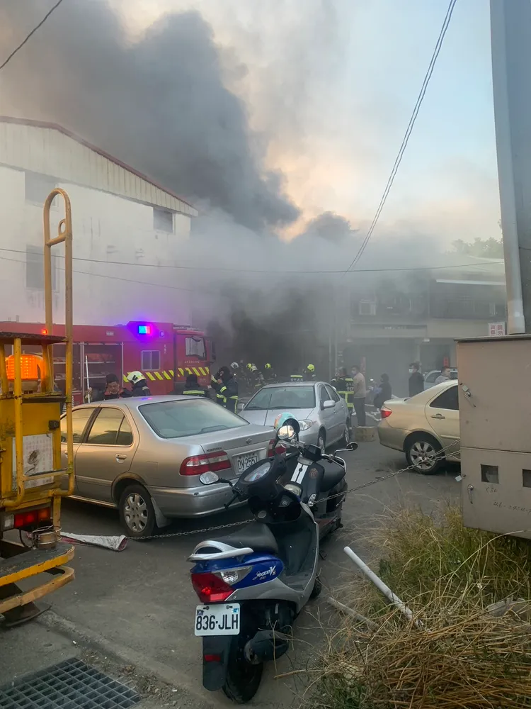 火警現場冒出大量濃煙直竄天際，消防人員緊急到場搶救。讀者提供