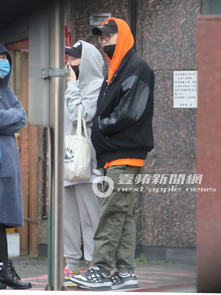 王子（右）素顏戴著黑框眼鏡，和經紀人在南港的路邊聊天，不忘穿著代言的亞瑟士品牌出門。特勤中心攝