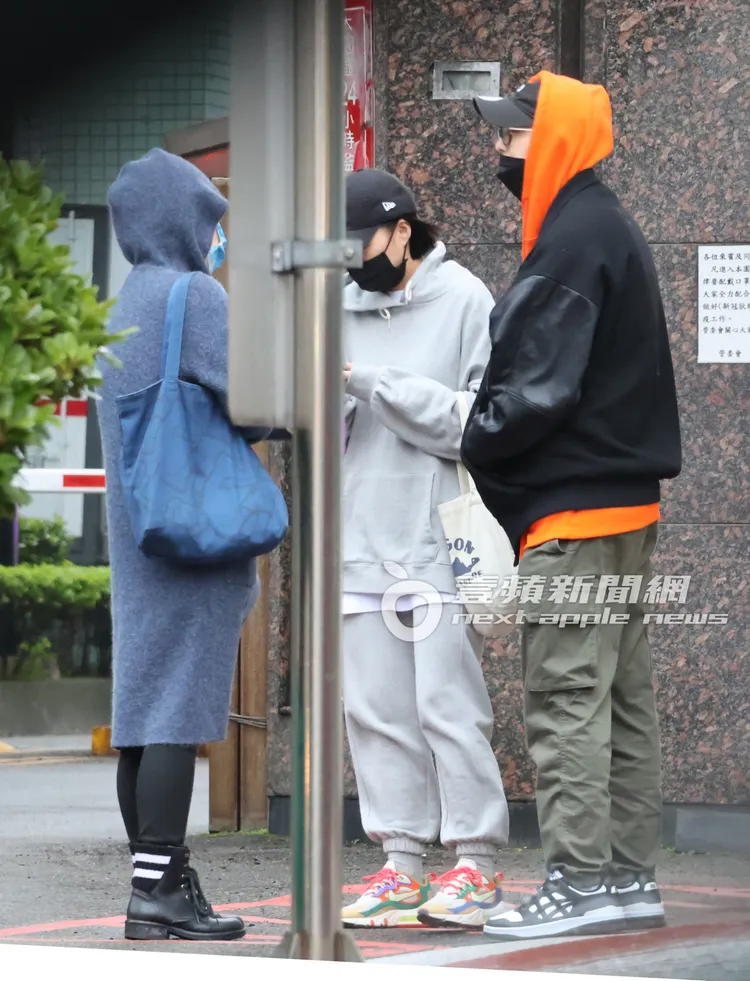 王子（右起）穿著代言的亞瑟士運動休閒鞋，和助理及經紀人站在路邊暢談。特勤中心攝