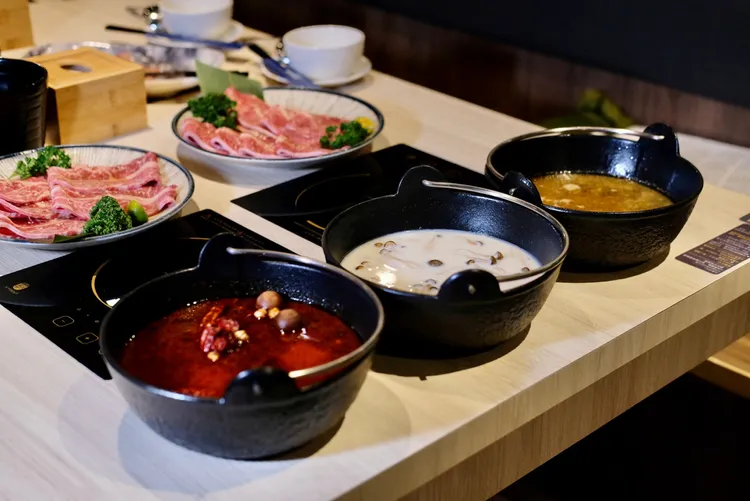 這裡提供14款湯鍋，最招牌的石頭湯底(右起)還有鮮菇奶香湯底、川味麻辣湯底。葉盛耀攝