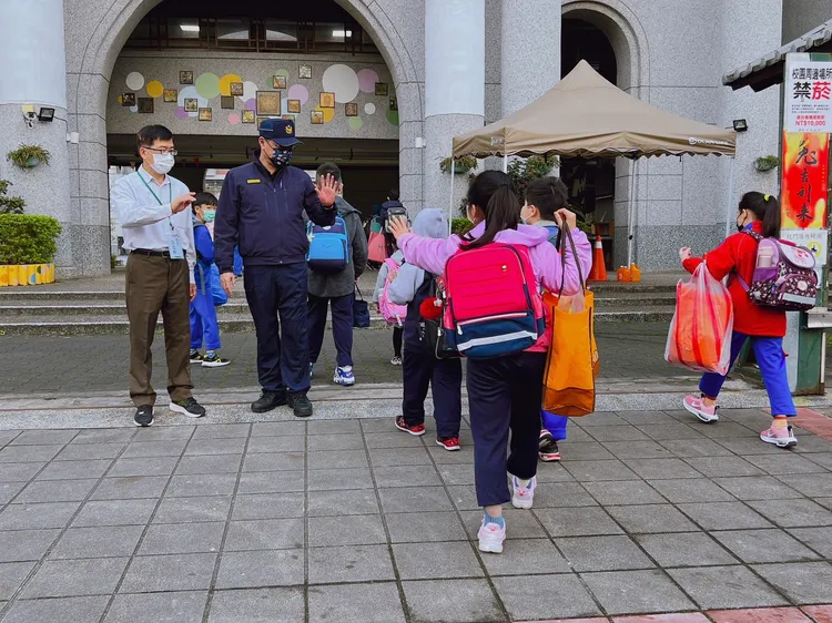 土城警方在校門口與上學的學童打招呼。土城警分局提供