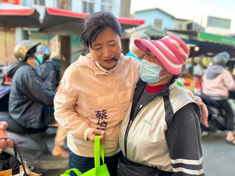 蔡培慧到南投菜市場拜票，親切地摟著攤商的肩膀爭取支持。蔡培慧總部提供