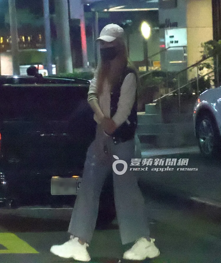 王心恬戴上白色鴨舌帽，下車後拉著外套準備過馬路。特勤中心攝