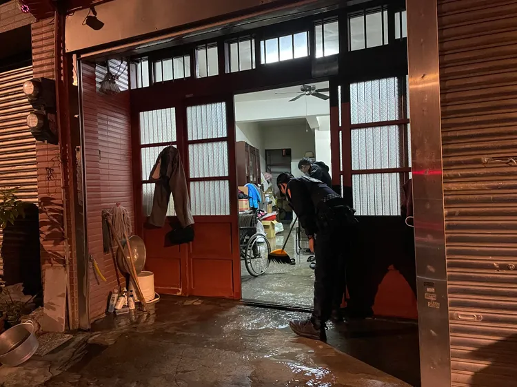 警員協助清除老翁家中積水。平鎮警分局提供