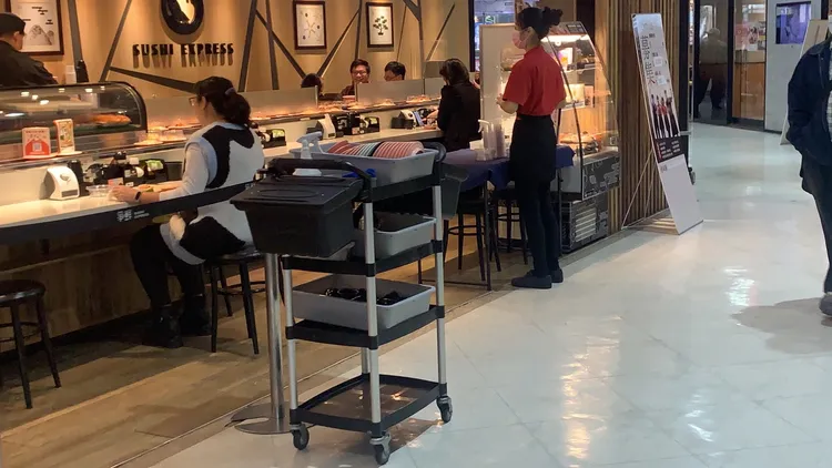 婦人發文指她到爭鮮愛河店用餐，卻看到鄰座男子將摸過食物，再放回壽司軌道上。讀者提供